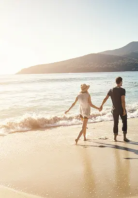 Couple strolling on a beach - Preferred Travel